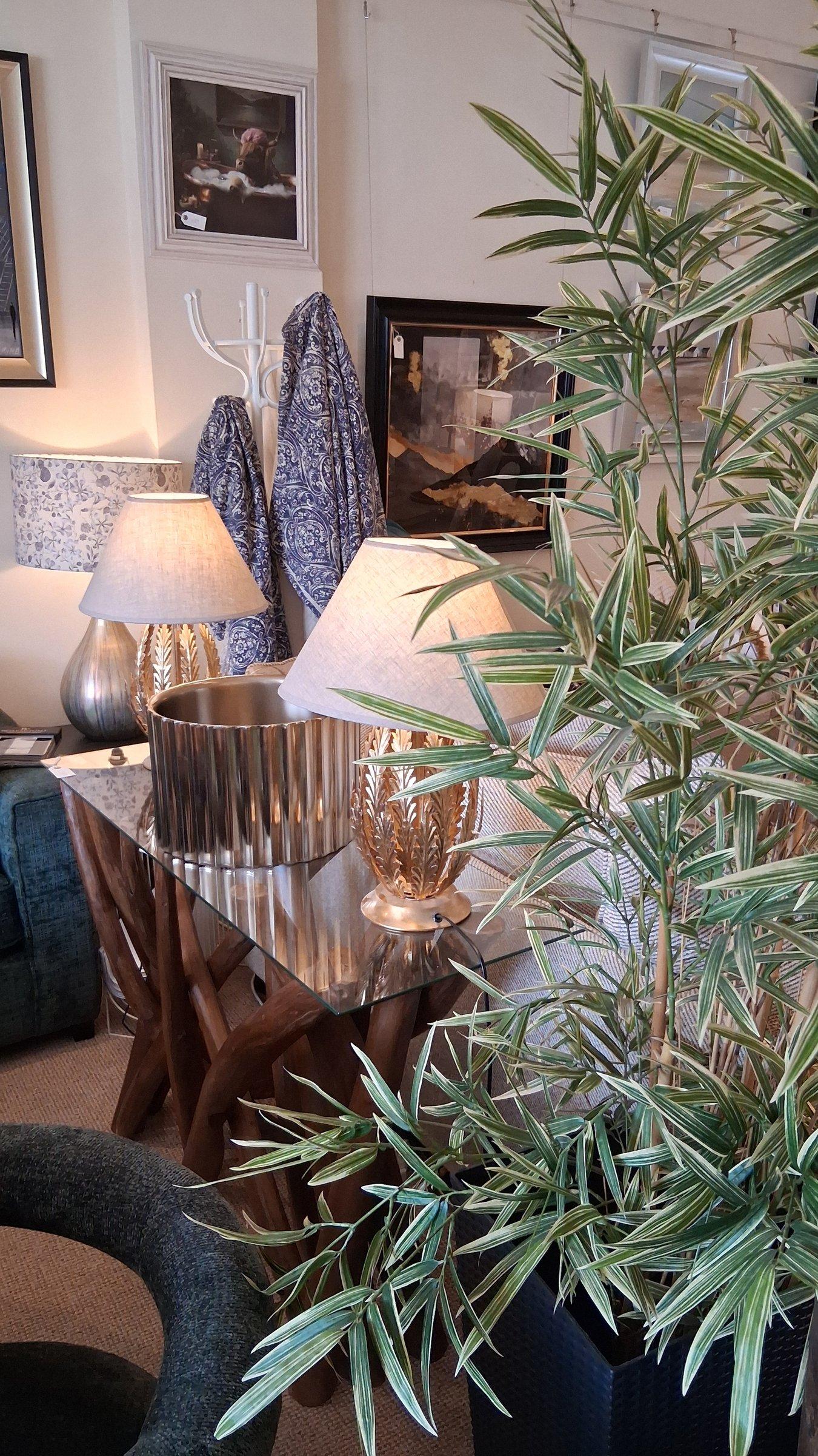 Lamps and lighting styled on a wooden console table with foliage