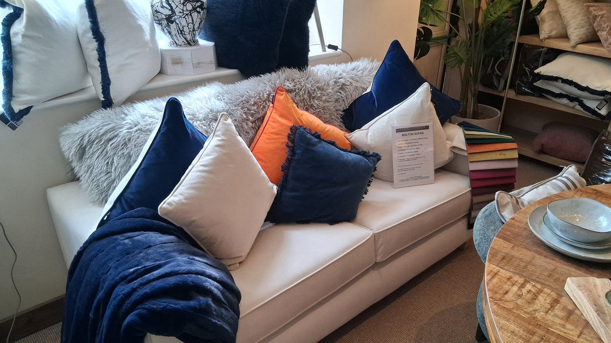 Cream Bolton sofa styled with navy, orange and cream cushions