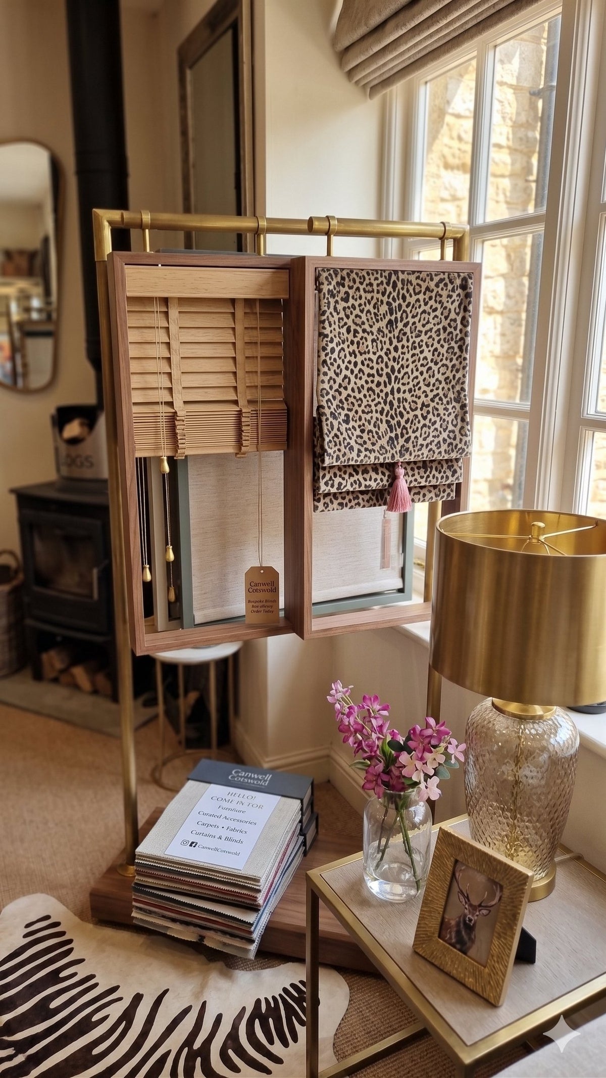 A blind display stand in the Canwell showroom, with a wooden Venetian blind and a printed Roman blind beside the window
