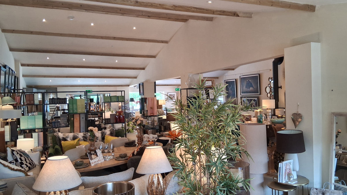 The main room of the Canwell showroom in Broadway, with beamed ceiling, lamps, sofas and a dining table